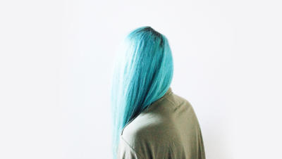 Woman facing away from the camera with long blue hair